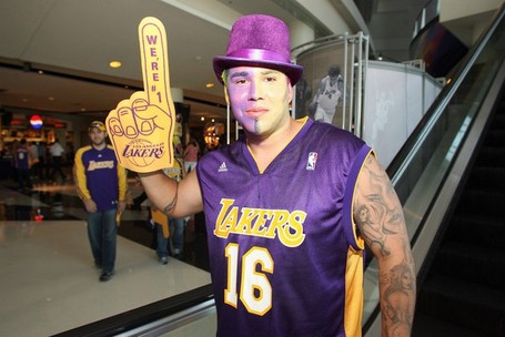 Laker_fan_is_painted_up_and_holds_up_a_foam_finger_medium
